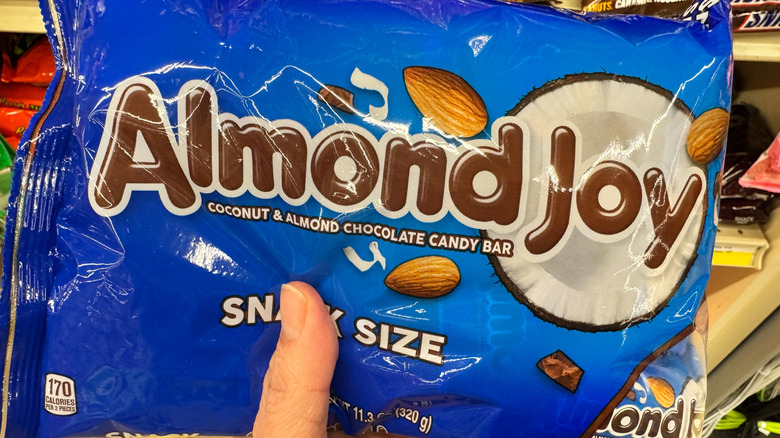 Hand holds a package of Almond Joy snack size candy bars at a grocery store