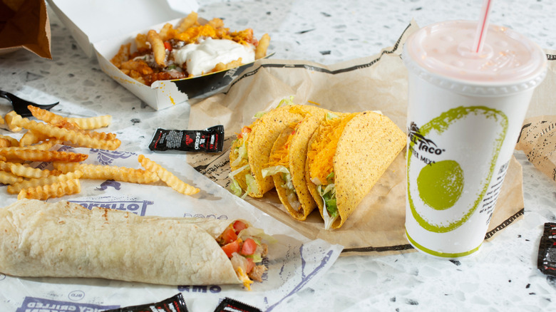 A view of a Del Taco combo meal with drink, tacos, wrap and fries