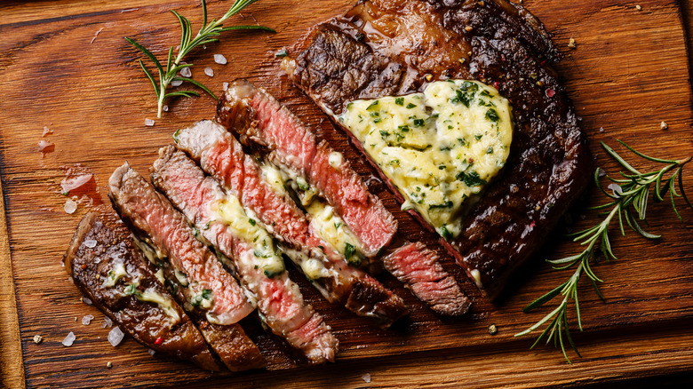 sliced grilled steak with herb butter