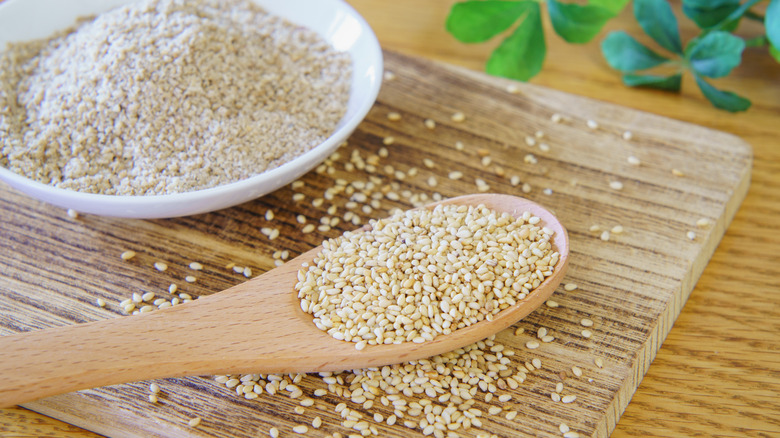 spoonful of raw sesame seeds bowl of ground sesame seeds
