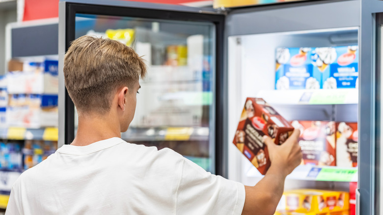 Man choosing frozen food from a supermarket freezer