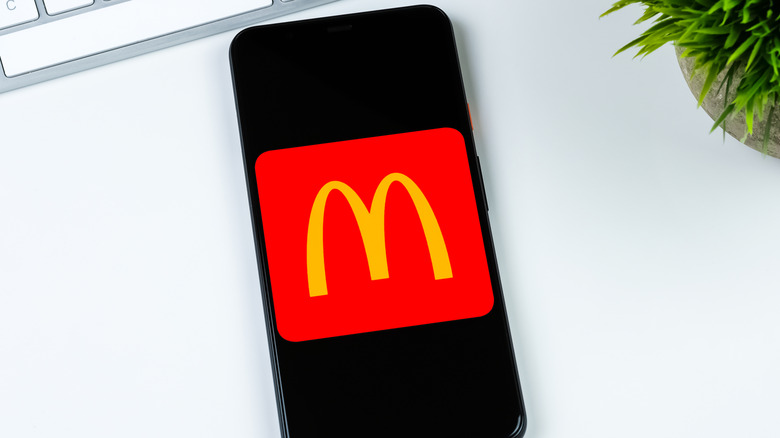 McDonald's app logo on a smartphone screen on white desk