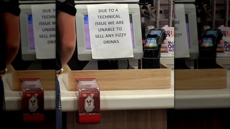 mirrored image of notice at McDonald's counter saying fizzy drinks are unavailable due to technical issues