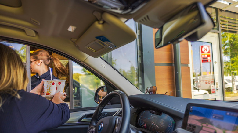 customer receiving drinks through car window at McDonald's