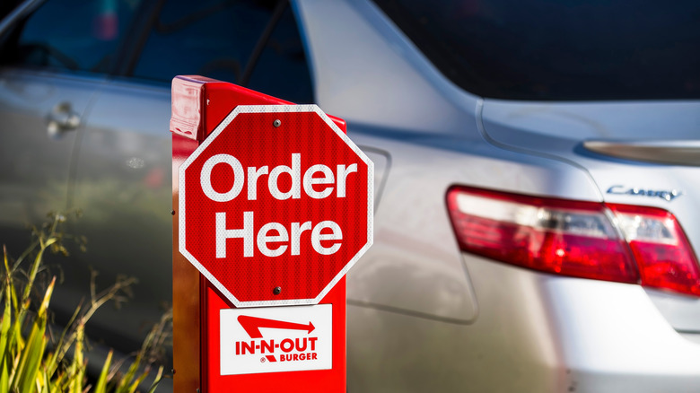 An In-N-Out Burger "Order Here" sign at a drive-thru.