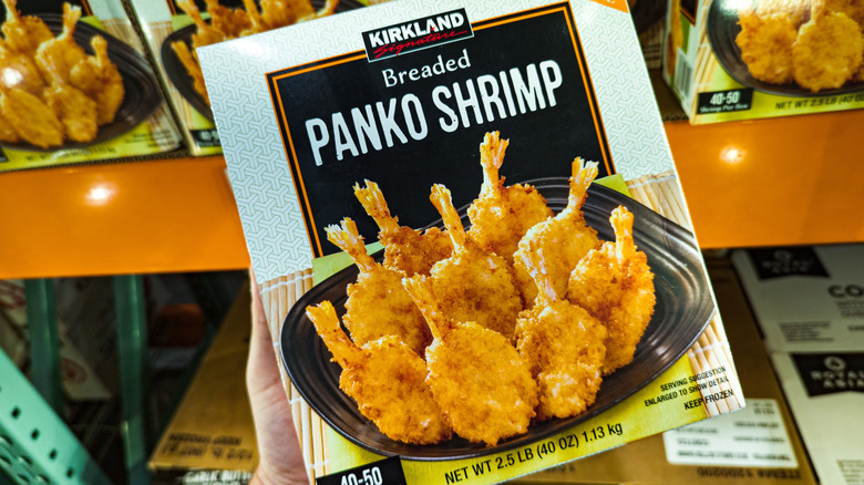 Costco member holding a package of Kirkland Signature Breaded Panko Shrimp