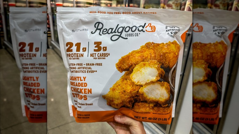Mirrored image of hand holding Realgood Foods Co chicken strips