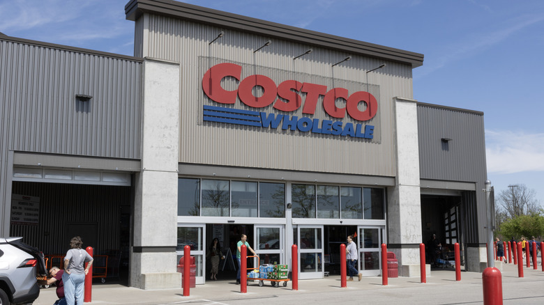 Costco storefront against blue sky with customers outside