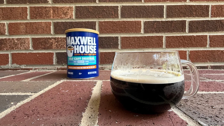 Cylindrical canister of half-caff ground coffee against brick wall