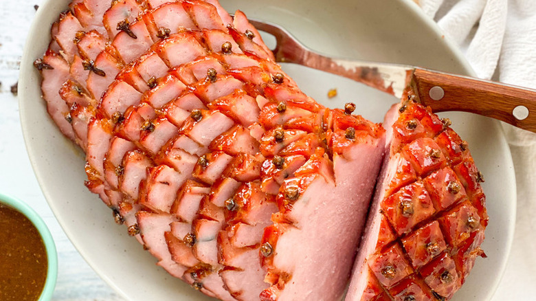 Sliced glazed ham in serving dish