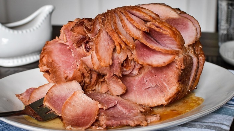 Sliced honey baked ham on serving plate