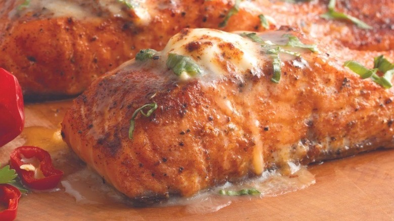 Two pieces of salmon on wooden surface