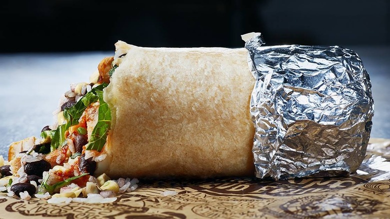Half-wrapped Chipotle burrito on grey table