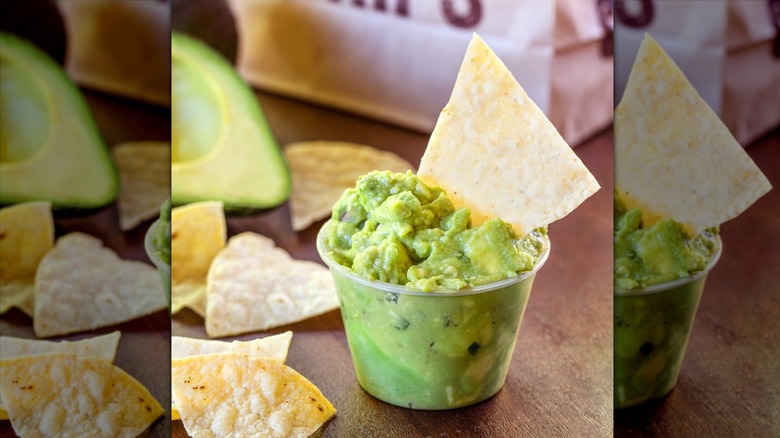 Small cup of guacamole with chip in it