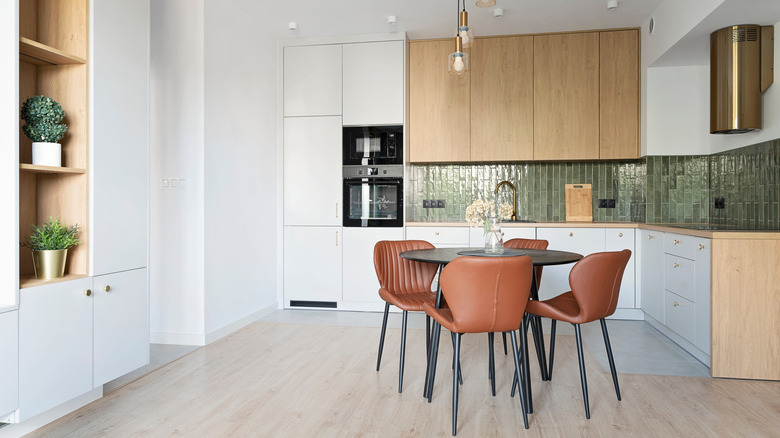 A modern looking kitchen with stylish green tile and wood cabinets