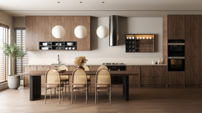 A kitchen designed with wood cabinetry and tan chairs to match