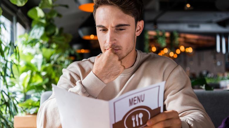Man reading menu at restaurant