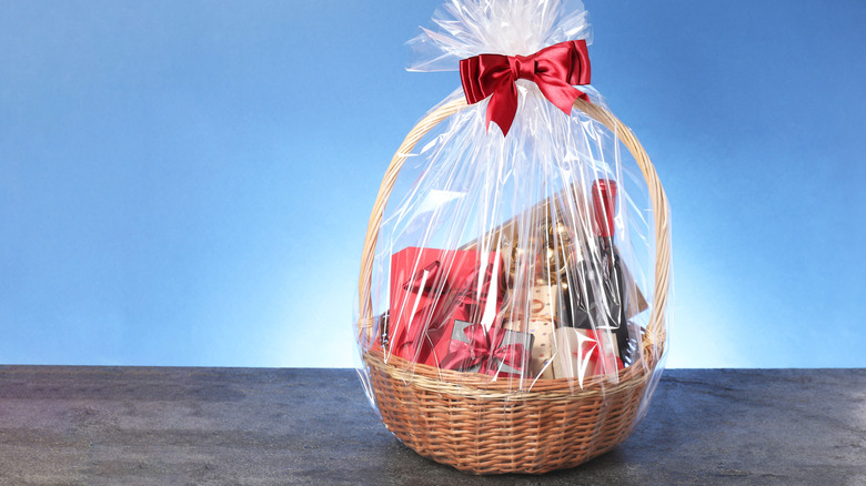 Gift basket wrapped in cellophane on blue background