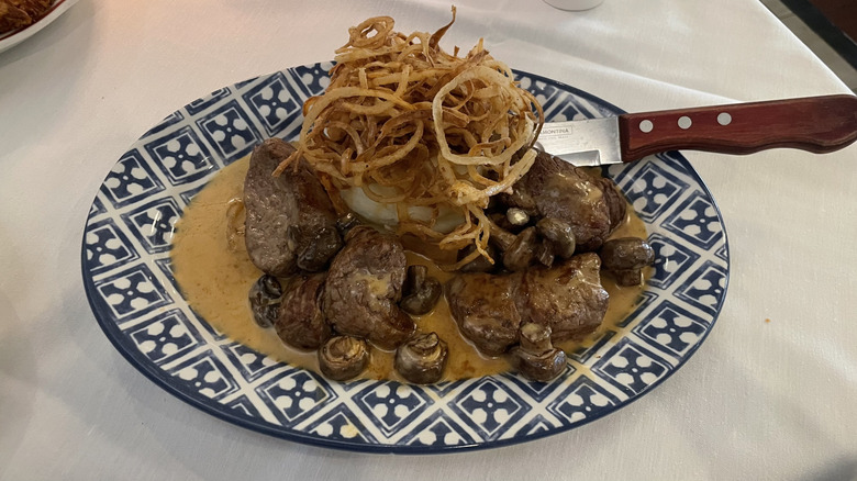 Beef tenderloin medallions with mashed potatoes, mushrooms, and fried onions
