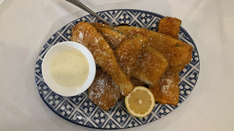 Fried zucchini slices with lemon sauce and slice lemon