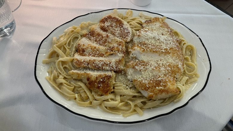 Chicken alfredo with fettuccine and freshly grated parmesan on a dish