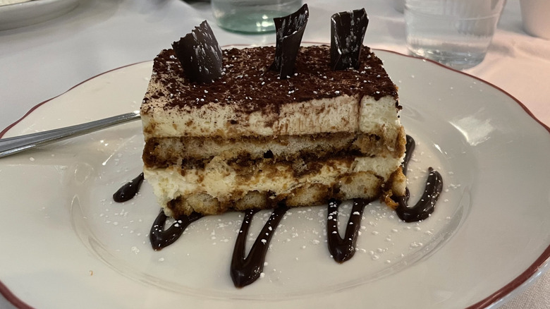 Tiramisu on a plate with chocolate sauce drizzle