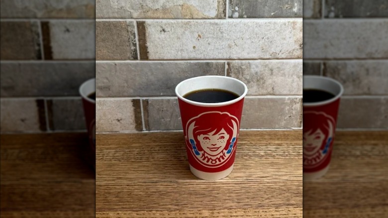 Cup of black coffee with brick background