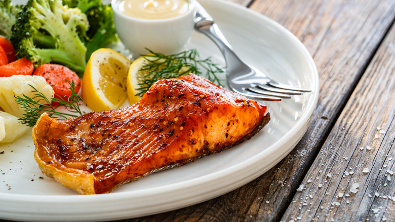 Crispy air fried salmon on white plate with salad