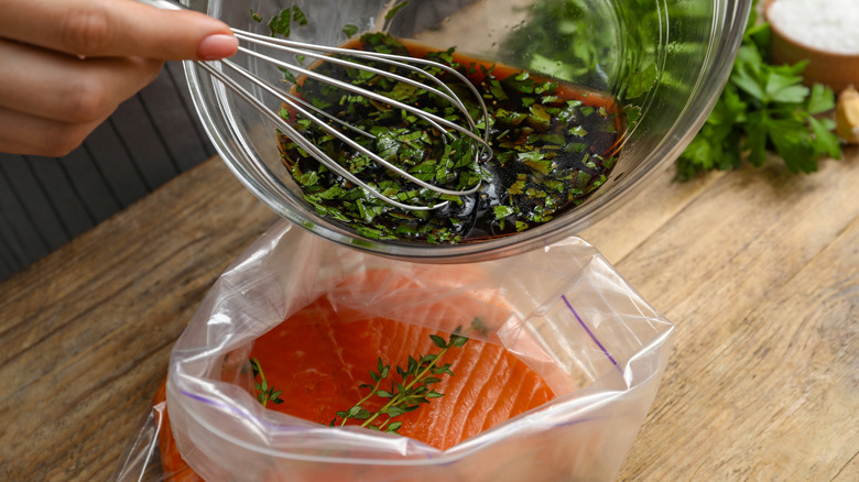 Marinade being poured over raw salmon