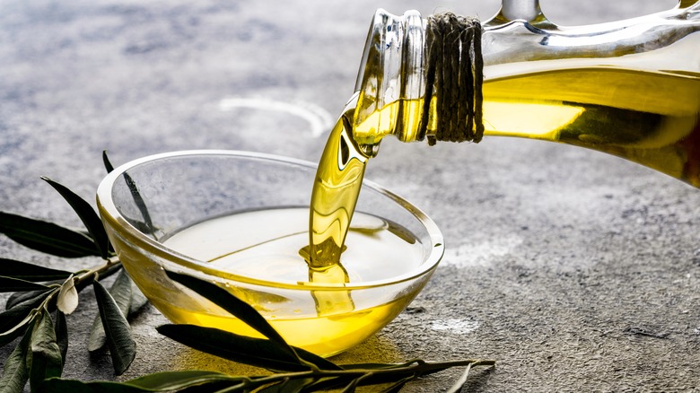 Olive oil pouring into small glass bowl