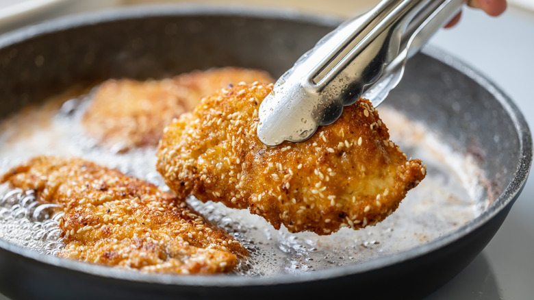 chicken cutlets in frying pan with oil
