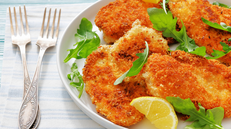 chicken cutlets on plate with arugula