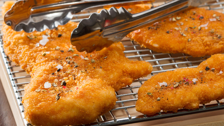 chicken cutlets resting on wire rack