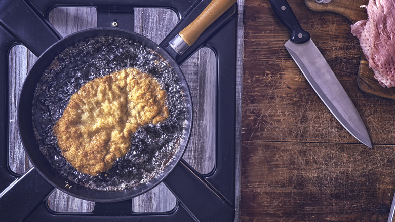 chicken cutlet frying in oil