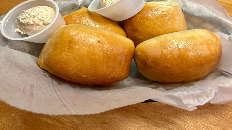 Texas Roadhouse rolls in paper-lined basket with butter