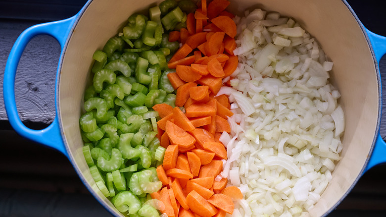 Blue Dutch oven with carrots, onions, and celery