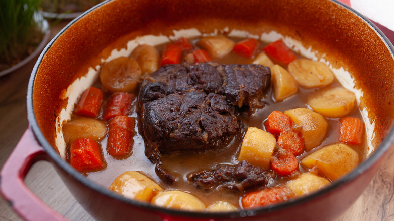 Pot roast with carrots and potatoes in Dutch oven