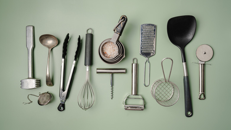 Various kitchen utensils on green background