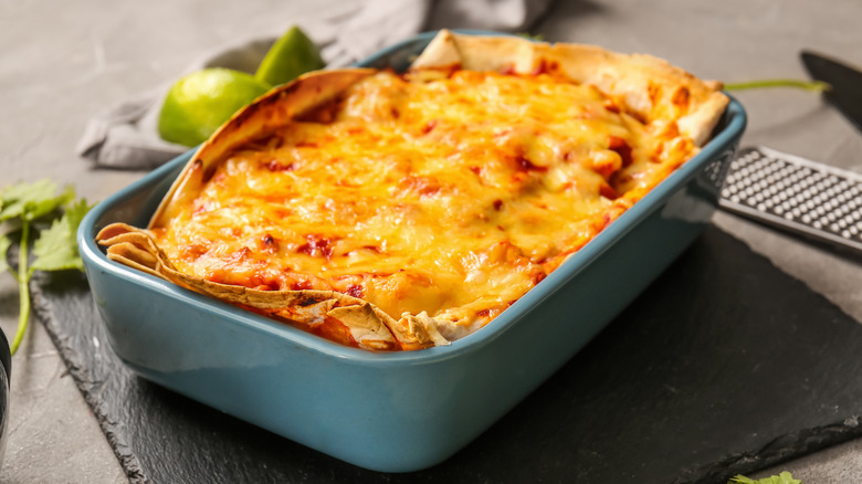 Blue baking dish with chicken enchiladas