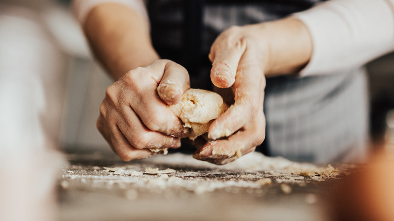 Person's hands kneading dough