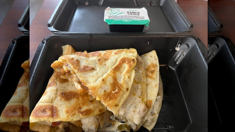 Zaxby's quesadilla with ranch sauce in black to-go box
