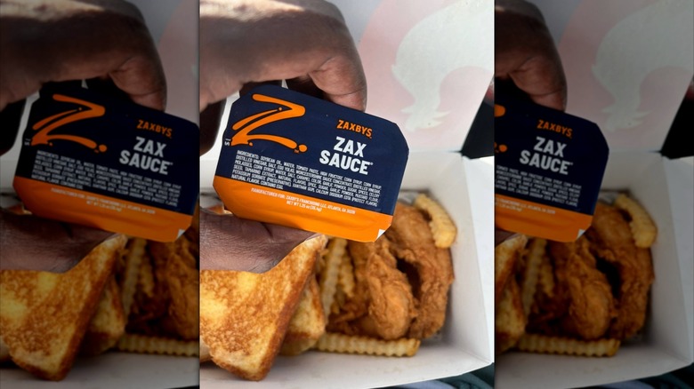 Hand holding Zaxby's Zax sauce packet