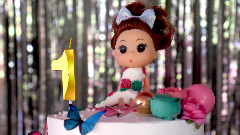 Birthday cake with a doll on top