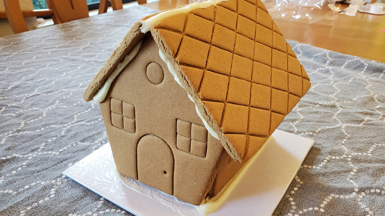 Undecorated gingerbread house on white base