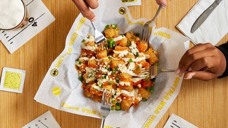 Forks reaching for Buffalo Wild Wings buffalo chicken tots