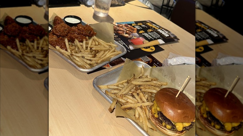 Wings and fries and burgers and fries on trays at Buffalo Wild Wings