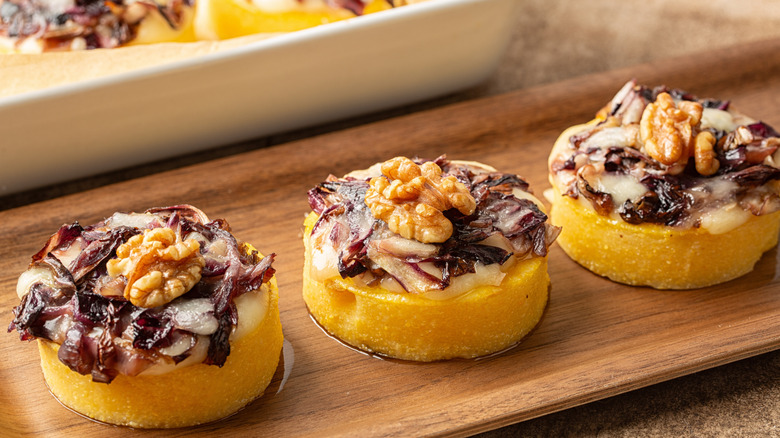 Polenta sliced into disks with toppings