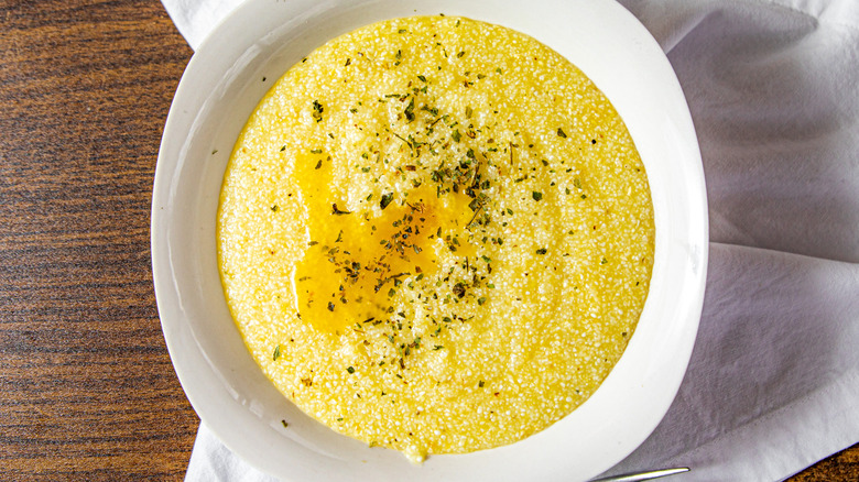 White bowl of grits with seasonings on top