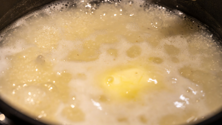 Pot of grits cooking with butter