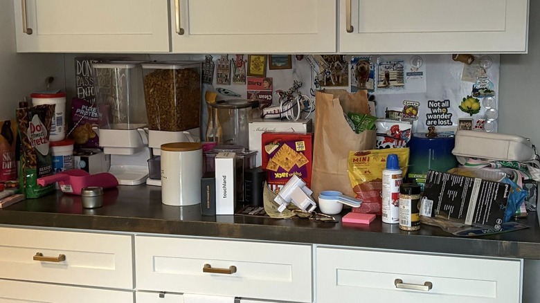 Cluttered kitchen counter with lots of food and utensils